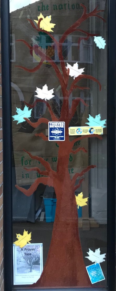 Picture of a tree with prayer leaves in church window